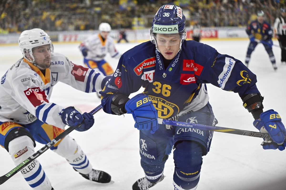 Der Davoser Simon Knak, rechts, gegen den Zuger Sven Leuenberger, im Eishockey-Qualifikationsspiel der National League (NL) zwischen dem HC Davos und dem EV Zug am Dienstag, 11. Februar 2025, in der z ...