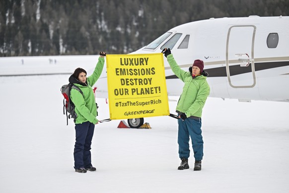 epa11844356 Greenpeace activists stage a protest in front of a private jet during the 55th annual meeting of the World Economic Forum (WEF), in Samedan, Switzerland, 22 January 2025. The World Economi ...