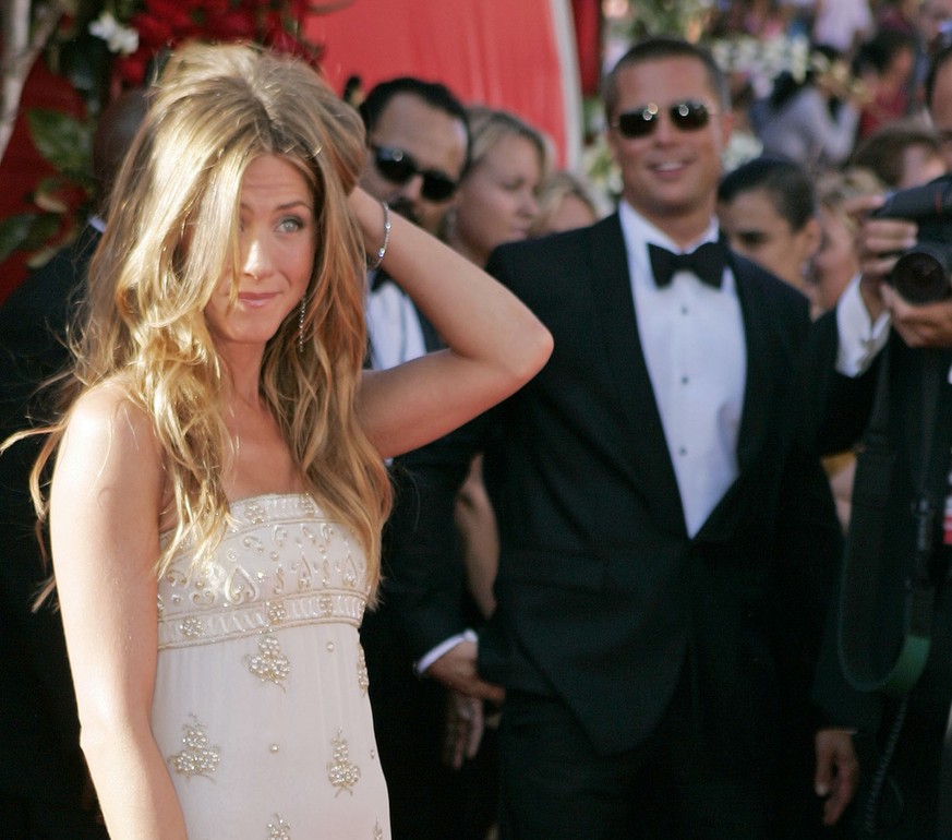 Jennifer Aniston gestures with husband Brad Pitt looking on as they arrive for the 56th Annual Primetime Emmy Awards Sunday, Sept. 19, 2004, at the Shrine Auditorium in Los Angeles. Anistonis nominate ...