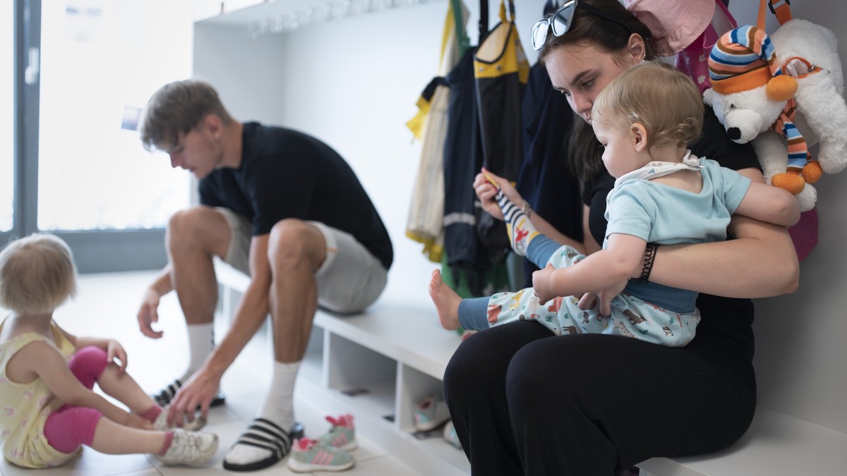 THEMENBILD ZUR LANCIERUNG DER KITA-INITIATIVE --- Betreuungspersonal hilft Kleinkindern beim Anziehen der Schuhe und Sonnenschutzkleidung, bevor es zum Spielen in den Aussenbereich der Kita 6a der Sti ...