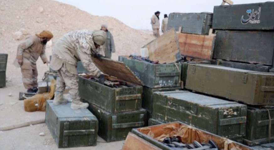 Islamic State fighters search weapon boxes in a Russian base in what is said to be Palmyra, Syria in this still image taken from video uploaded to social media on December 13, 2016. Amaq News Agency/H ...