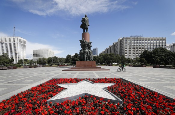 epa10082496 A bed of red flowers shapes the form of a star in front of a statue of the founder of the Soviet Union, Vladimir Lenin, in Moscow, Russia, 20 July 2022. EPA/YURI KOCHETKOV