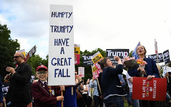 epa07623067 An anti Trump protester holding a placard outside Buckingham Palace in central London, Britain, 03 June 2019. US President Trump and his wife Melania are on a three-day official visit to B ...