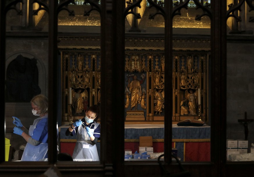 The Pfizer-BioNTech coronavirus vaccine is prepared by health workers at Salisbury Cathedral, in Salisbury, England, Saturday, Jan. 16, 2021, before being administered to members of the public. The hi ...