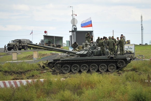 FILE - Recruits listen to an instructor standing atop of a tank during a military training at a firing range in the Rostov-on-Don region in southern Russia, Oct. 4, 2022. Since Russian President Vladi ...