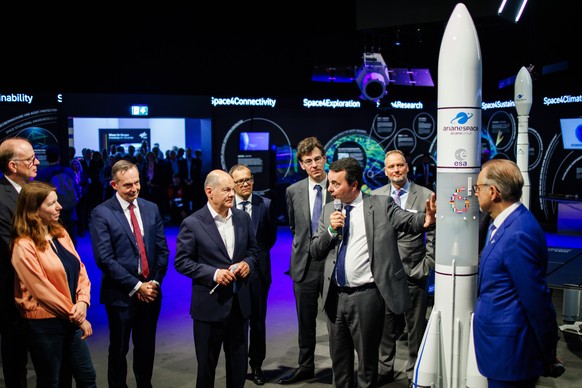 epa11390780 German Chancellor Olaf Scholz (4-L), stands next to German Minister for Transport and Digital Affairs Volker Wissing (3-L) as CEO of ArianeGroup Martin Sion (7-L) talks on front of an Aria ...