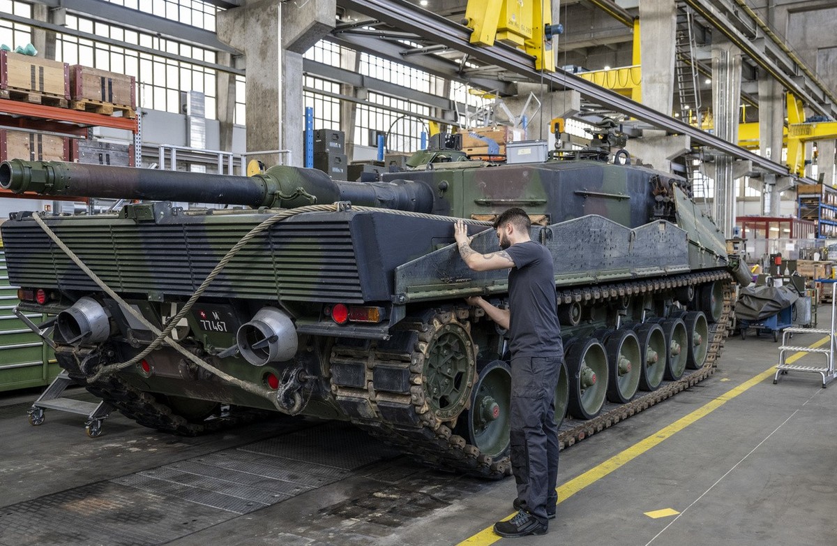 Ein Mechaniker wartet die Raupen an einem Panzer vom Typ Leopard 2 in einer Wartungshalle der RUAG, am Montag, 20. Maerz 2023, in Thun. (KEYSTONE/Peter Schneider)