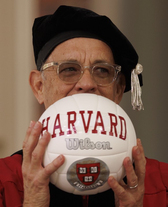 epa10653399 Actor Tom Hanks holds a Harvard University emblazoned volleyball as he receives his Honorary Doctor of Arts degree, during the 372nd Commencement ceremonies at Harvard University in Cambri ...