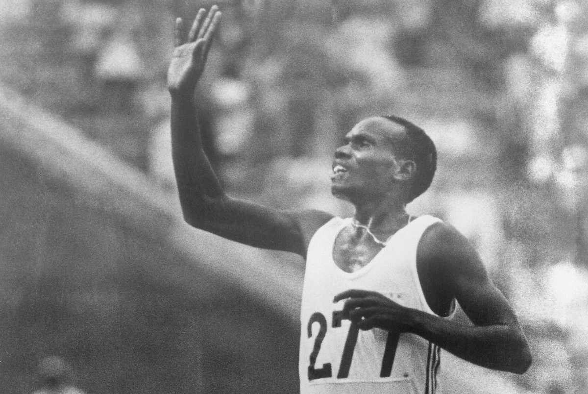 FILE - Henry Rono of Kenya waves to the crowd as he crosses the finish line to win the Gold medal in the men's 5,000metres event, in the Commonwealth Stadium, during the 11th Commonwealth Games i ...