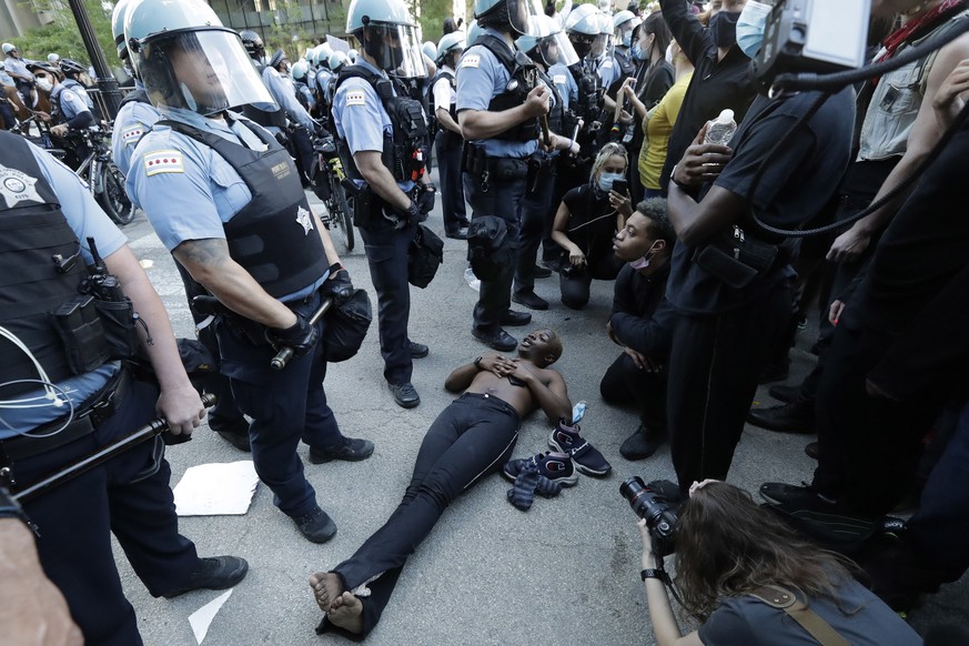 People confront police officers during a protest over the death of George Floyd in Chicago, Saturday, May 30, 2020. Protests across the country have escalated over the death of George Floyd who died a ...