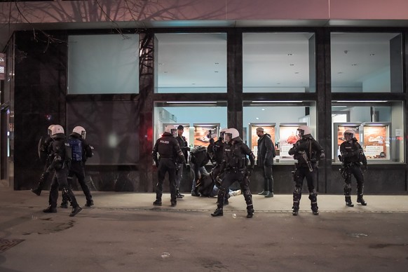 Polizisten nehmen einen Jugendlichen fest, am Freitag, 2. April 2021, in St. Gallen. In der St. Galler Innenstadt haben Jugendliche am Freitagabend die Polizei attackiert. Sie bewarfen die Einsatzkrae ...