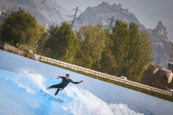 epa09163305 A surfer rides an artificial wave in the "Alaia Bay" surf wavepool during a press day, in Sion, Switzerland, 27 April 2021. EPA/VALENTIN FLAURAUD
