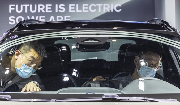 epa09149400 People look at the electric car on display in the Volvo trade fair stand at the Auto Shanghai 2021 motor show in Shanghai, China, 21 April 2021. The 19th International Automobile Industry  ...