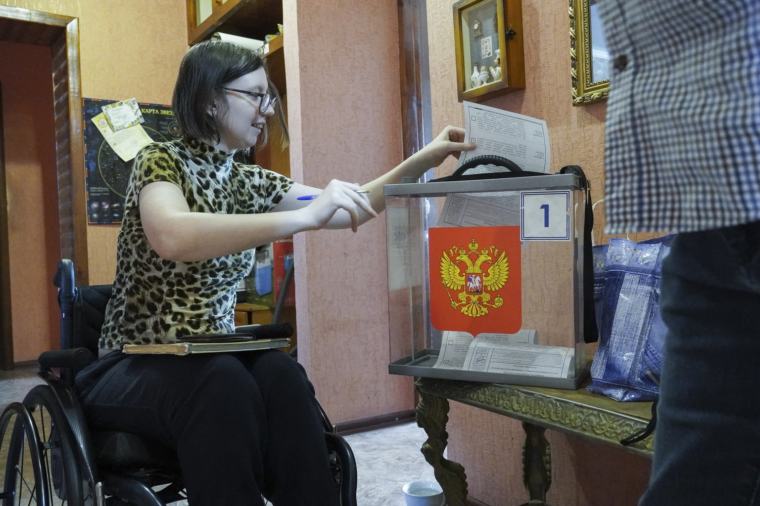 epa11593067 A woman casts her ballot to elect the new Kursk regional governor during the single election day, at a polling station in Kursk, Russia, 08 September 2024. Four candidates are running for  ...