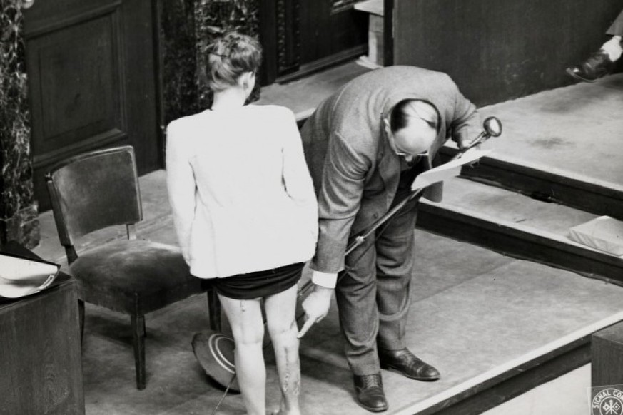 Eine Überlebende der Gasbrand-Versuche zeigt ihre Wunden am Nürnberger Ärzteprozess, 1946.