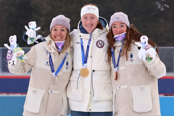 epa12739077 (L-R) Silver medal winner Oceane Michelon of France, gold medal winner Maren Kirkeeide of Norway and bronze medal winner Lou Jeanmonnot of France pose during the award ceremony for the Wom ...
