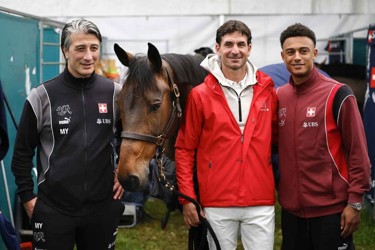 Murat Yakin, Trainer der Schweizer Fussball Nationalmannschaft, Springreiter Steve Guerdat und Fussball Nationalspieler Dan Ndoye, von links, posieren mit Guerdat's Pferd Venard de Ceresy im Stal ...