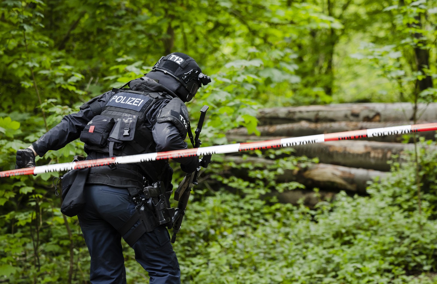 Ein Polizist der Einsatzgruppe Diamant auf einem gesperrten Waldweg im Huerstwald, am Donnerstag, 5. Mai 2022 in Zuerich. Die Kantonspolizei Zuerich sperrte den Huerstwald im Zusammenhang mit einem St ...