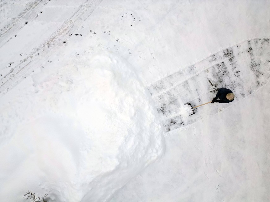Luftaufnahme. Winter im Siegerland. Eine Person raeumt r�umt bereits zum zweiten mal am Morgen mit einem Schneeschieber ihr Grundstueck Grundst�ck. Es hat sehr viel geschneit. Winter im Siegerland am  ...