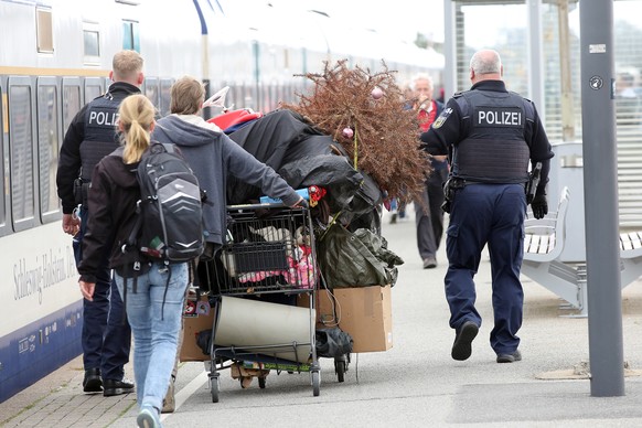 Police officers escort the participants of the evacuated punk protest camp on Sylt at the Westerland train station to their train to Hamburg.
