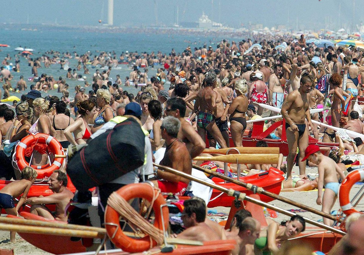 People gather on the beach of Torre del Lago, in Tuscany's Versilia riviera, Sunday 26 June 2005, to enjoy the high temperatures during the first weekend of the summer. (KEYSTONE/EPA/FRANCO SILVI ...