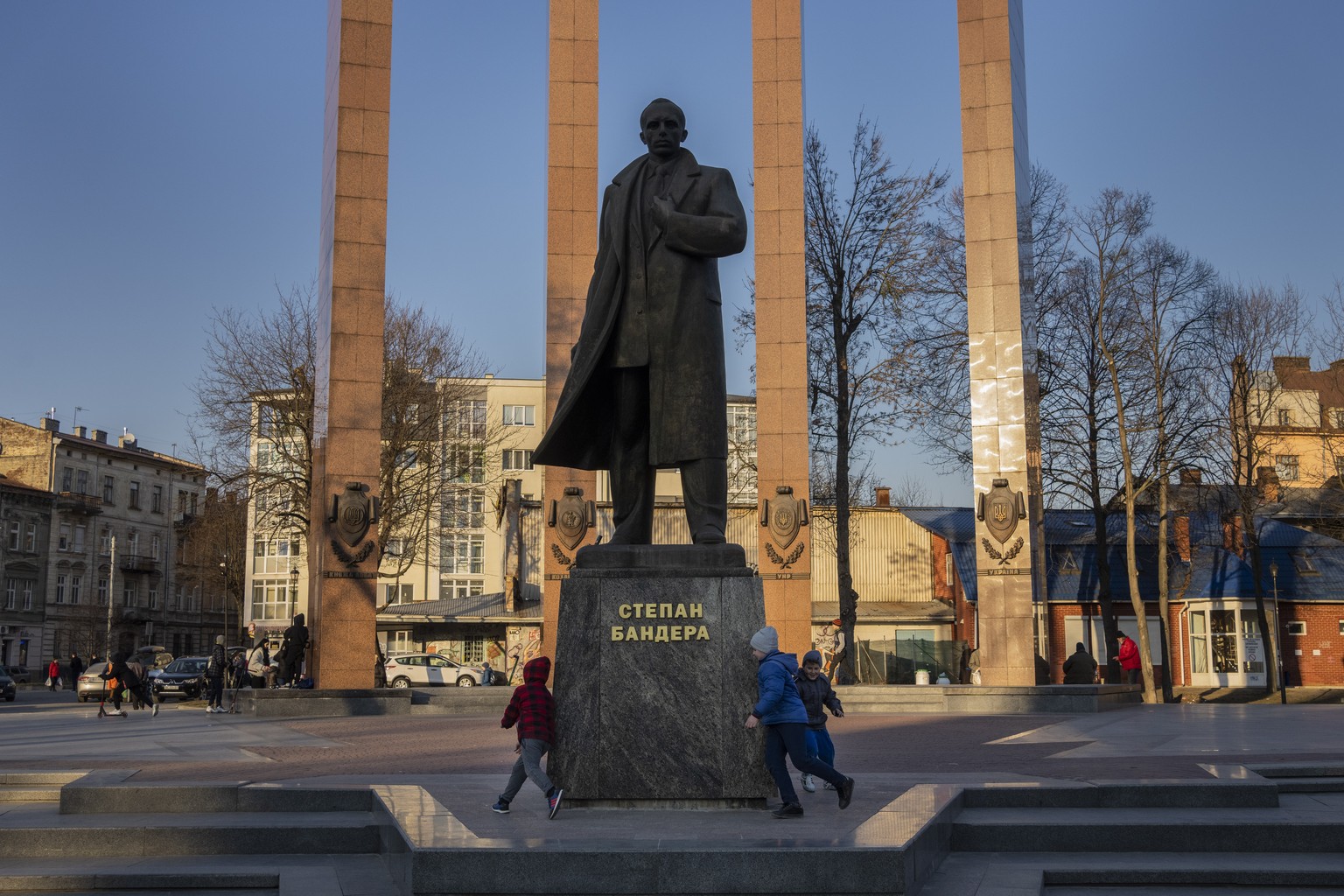 Children play around the monument to Stepan Bandera in Lviv, Western Ukraine, Saturday, March 19, 2022. (AP Photo/Bernat Armangue)