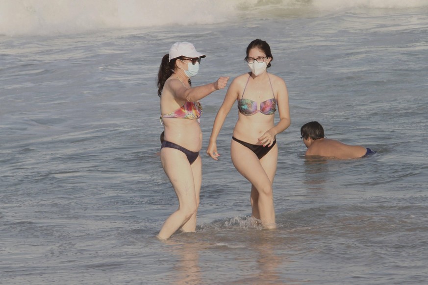 Strandspaziergänge mit Masken? Zwei vorsichtige Frauen in Cascais, in der Nähe von Lissabon, Portugal. 