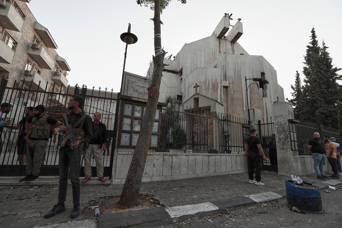 Syrian security forces stand guard outside Mar Elias church where a suicide bomber detonated himself in Dweil'a in the outskirts of Damascus, Syria, Sunday June 22, 2025. (AP Photo/Omar Sanadiki) ...