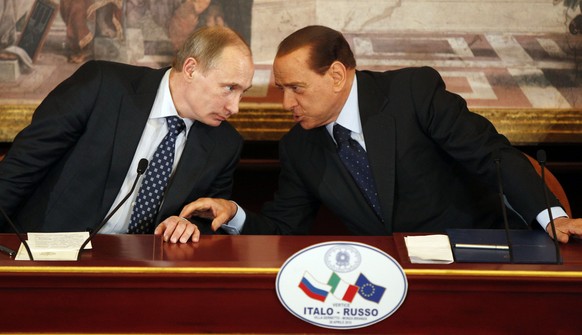 FILE - In this April 26, 2010 file photo Italian former Premier Silvio Berlusconi, right, and Russian Prime Minister Vladimir Putin talk during a press conference at Villa Gernetto, in Gerno, near Mil ...