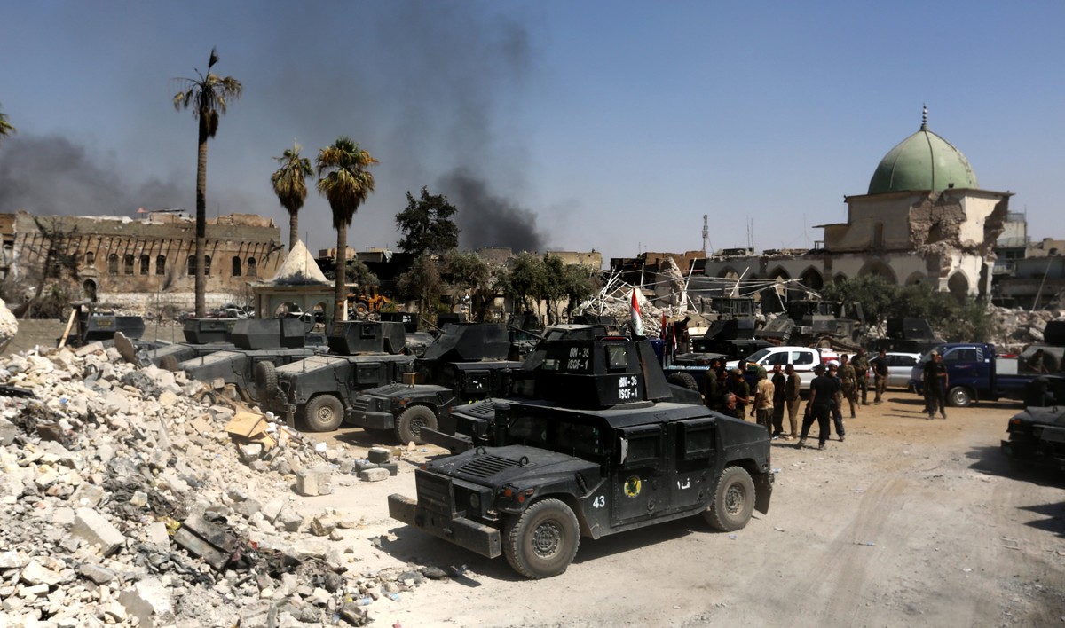 epa06068254 Iraqi security forces gather next to the destroyed Great Mosque of al-Nuri and Mosul's iconic al-Habda' minaret in the old city area, western Mosul, Iraq, 05 July 2017. Iraqi sec ...