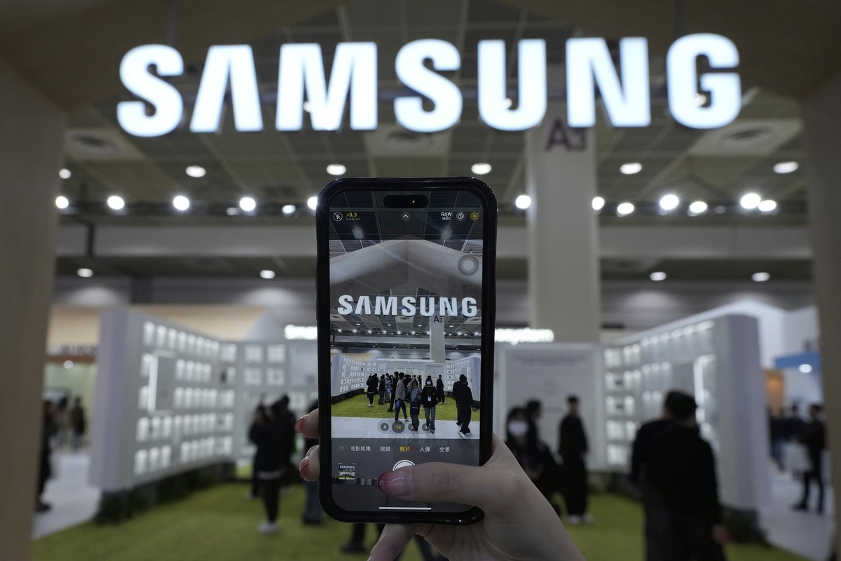 FILE - A visitor takes a picture of the logo of Samsung Electronics at its booth during The Semiconductor Exhibition 2024 at the COEX convention center in Seoul, South Korea, Wednesday, Oct. 23, 2024. ...