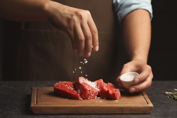 Chef cooking meat on table