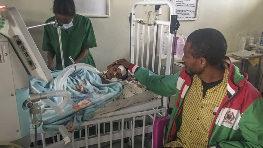 FILE - In this photo provided anonymously, Rahwa Mehari, 4, is comforted by her father who says she first suffered from malnutrition and medical records show then developed a cerebral tuberculoma, at  ...