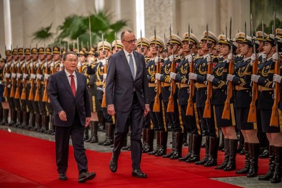 epa12775436 Chancellor of Germany Friedrich Merz (C) is welcomed with military honors at the Great Hall of the People by Li Qiang (L), Premier of China, in Beijing, China, 25 February 2026. Merz is vi ...