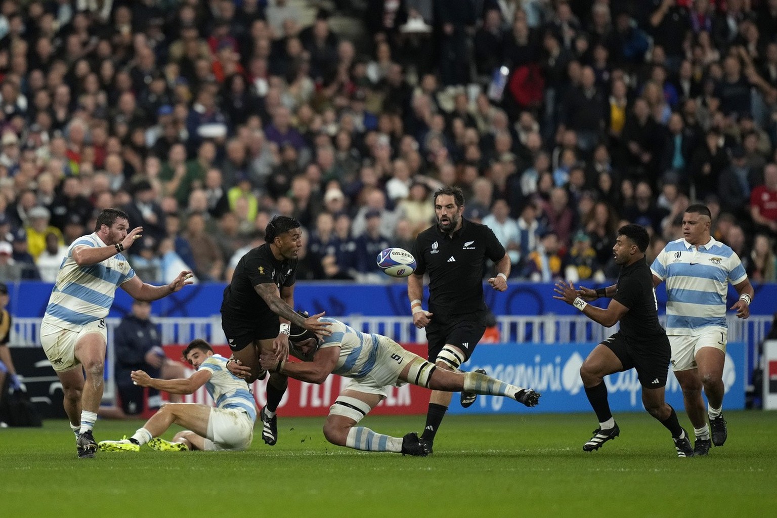 New Zealand&#039;s Rieko Ioane , second left, passes the ball to New Zealand&#039;s Richie Mo&#039;unga, second right, during the Rugby World Cup semifinal match between Argentina and New Zealand at t ...