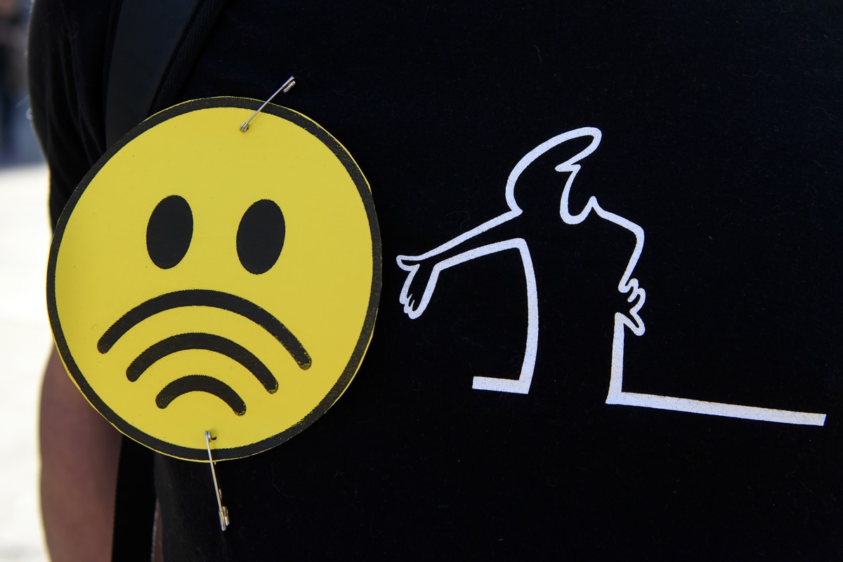 Ein Demonstrant mit einem Emoji mit Signalstaerke-Anzeige und der Zeichentrickfigur "La Linea" waehrend einer Demonstration gegen die Einfuehrung von 5G, am Samstag, 21. September 2019 auf d ...