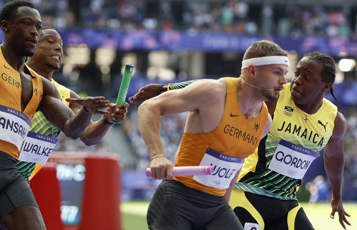 epa11536073 Jelani Walker of Jamaica hands the baton to Jehlani Gordon of Jamaica while Owen Ansah of Germany hands over to Yannick Wolf of Germany during the Men 4x100m Relay round 1 of the Athletics ...