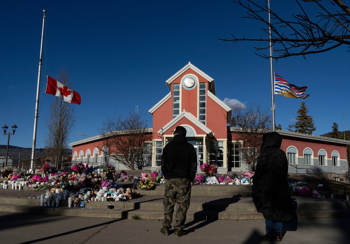 People pay their respects at a memorial on the steps of the Town Hall following a vigil the previous day in Tumbler Ridge, B.C., Saturday, Feb. 14, 2026. (Christinne Muschi/The Canadian Press via AP)
 ...