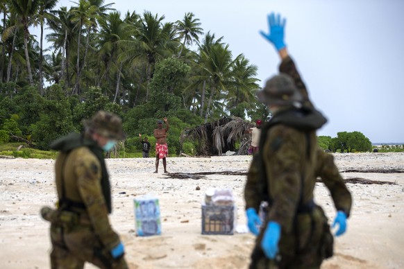 epa08582830 A handout photo made available by the Australian Department of Defence shows Australian Army soldiers from 2nd Battalion, the Royal Australian Regiment, delivering food and supplies to thr ...