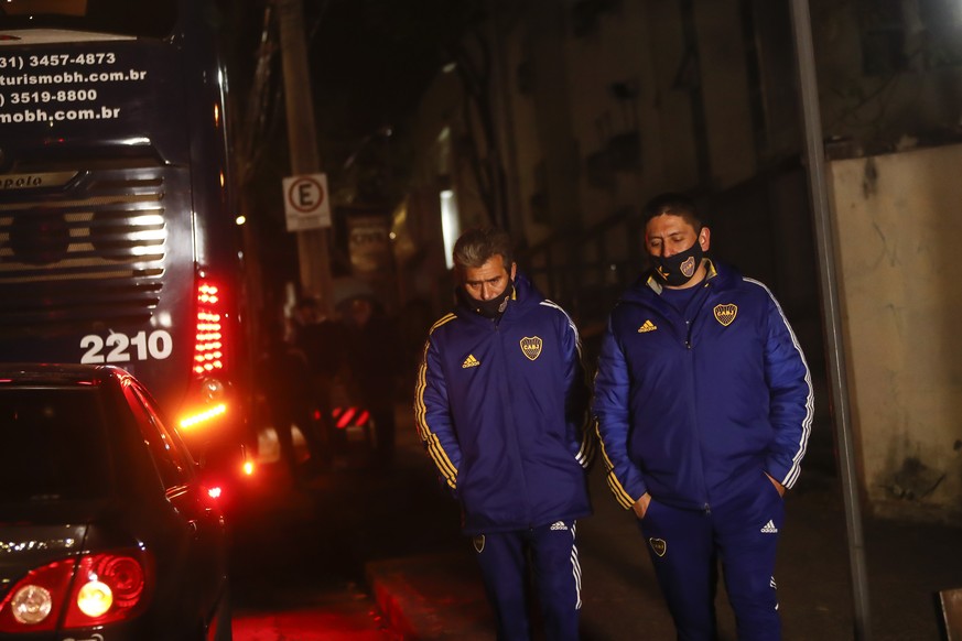 Unidentified staff members of Argentina&#039;s Boca Juniors soccer team stand outside a bus carrying their team as it&#039;s parked outside a police station in Belo Horizonte, Brazil, early Wednesday, ...