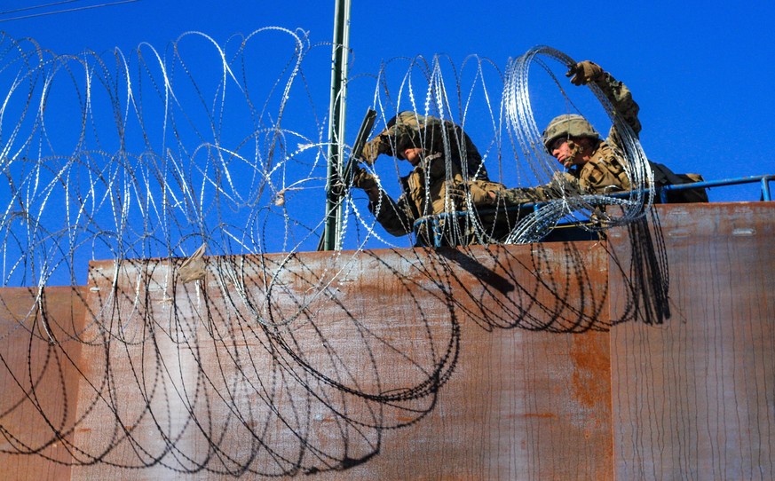 epaselect epa07161701 US military soldiers install barbed wire on the border with Mexico as seen from Colonia Libertad in Tijuana, Mexico, 12 November 2018. Around 4,000 migrants departed in the morni ...