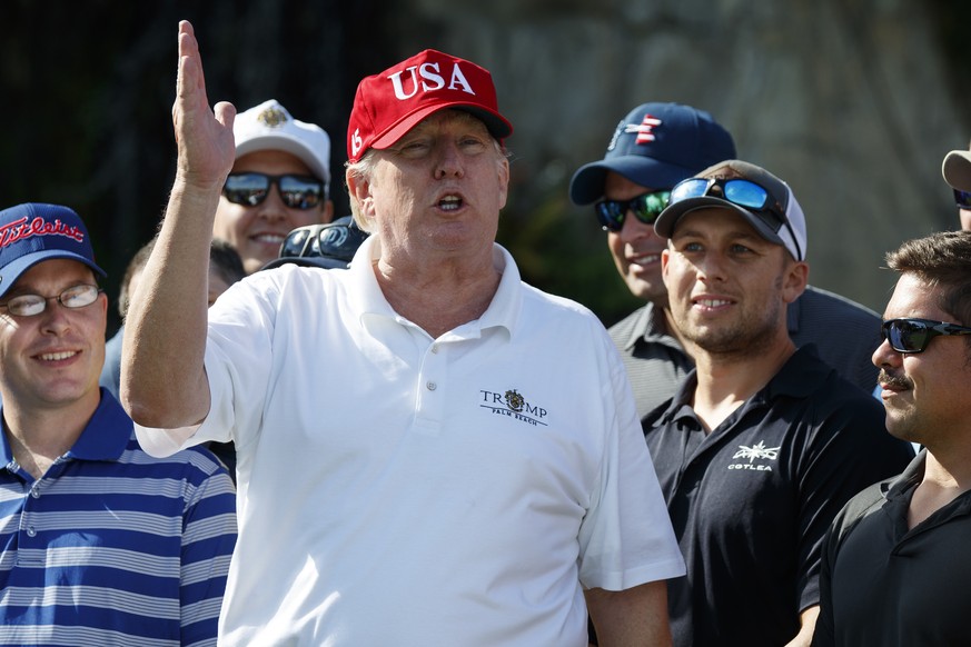 President Donald Trump speaks as he meets with members of the U.S. Coast Guard, who he invited to play golf, at Trump International Golf Club, Friday, Dec. 29, 2017, in West Palm Beach, Fla. (AP Photo ...