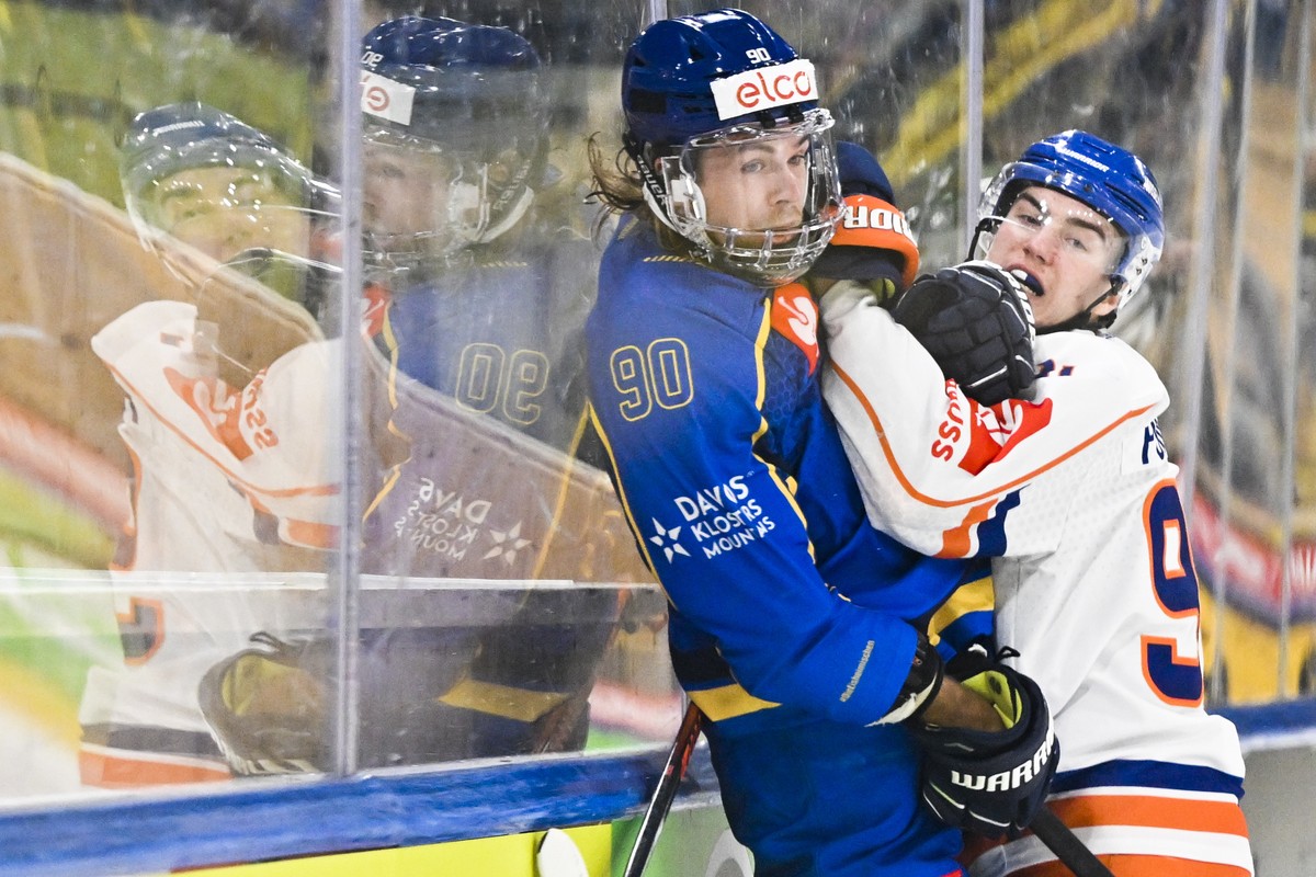 epa10307544 Davos' Sven Jung, left, versus Tampere's Petteri Puhakka during the Champions Hockey 1/8 final game between Switzerland's HC Davos and Finland's Tappara Tampere, in Dav ...
