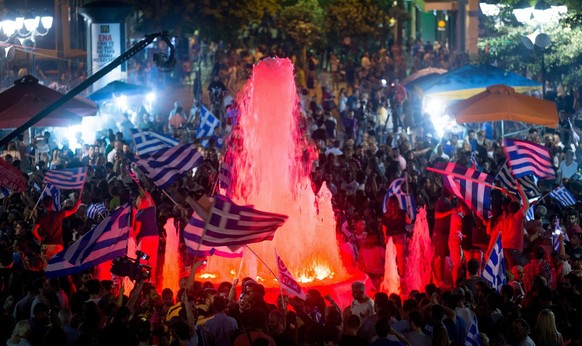 epa04832994 Supporters of the Syriza party and No vote campaign wave flags and react after results of the referendum in front of Greek Parliament in central Athens, Greece, 05 July 2015. Greek voters  ...