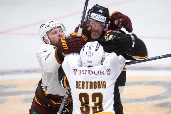 From left Geneva&#039;s players Richard Tanner and Alessio Bertaggia fight with Lugano&#039;s player Mirco Mueller during the preliminary round game of National League Swiss Championship 2023/24 betwe ...