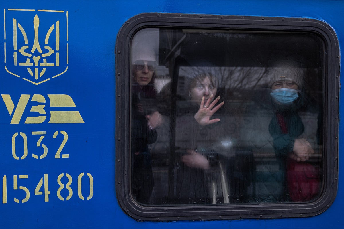 epaselect epa09801388 Women look out from inside an evacuation train to the city of Kiev (Kyiv), at the train station in Irpin, Ukraine, 04 March 2022. People, mostly women, and children, were fleeing ...