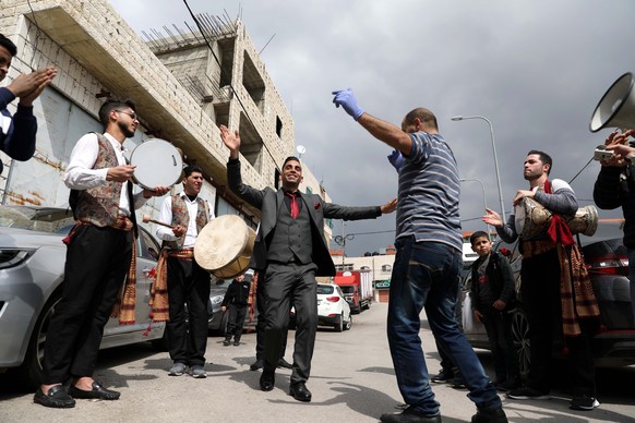 epa08369260 Palestinians dance during a wedding in the West Bank city of Hebron, 17 April 2020. Palestinian authorities imposed restrictions ordering people to stay at home and baning public gathering ...