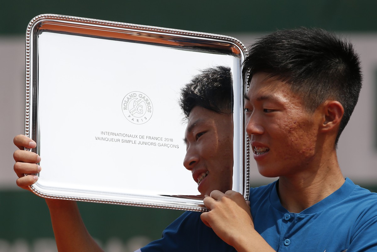 Taiwan's Tseng Chun Hsin shows his trophy after defeating Argentina's Sebastian Baez in their boy's singles final match of the French Open tennis tournament at the Roland Garros stadium ...