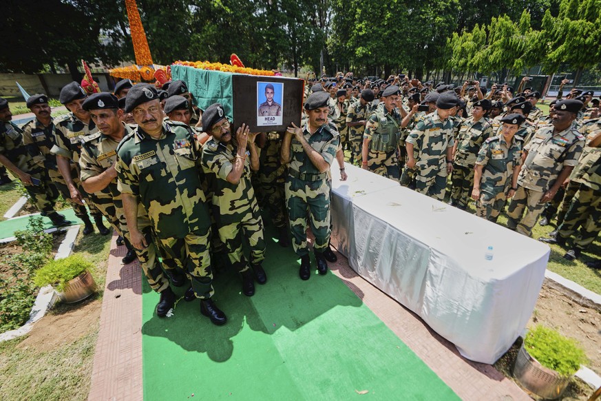 Indian Border Security Force (BSF) Soldiers carry a coffin containing the remains of a fellow soldier Deepak Chimngakham, who was killed in cross border Pakistani artillery shelling, in Jammu, India,  ...