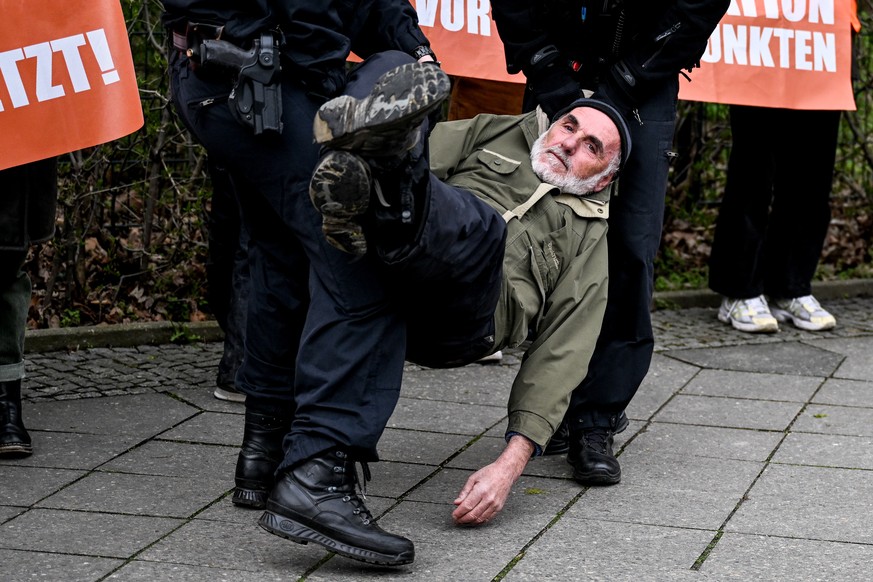 epaselect epa10581529 Police officers detain a Letzte Generation (Last Generation) climate activist as others block a road in front of Victory&#039;s Column in Berlin, Germany, 20 April 2023. They dem ...
